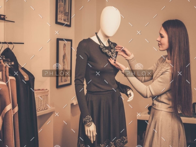 demo-attachment-955-young-woman-looking-at-necklace-on-mannequin-in-PSQQMMH-1